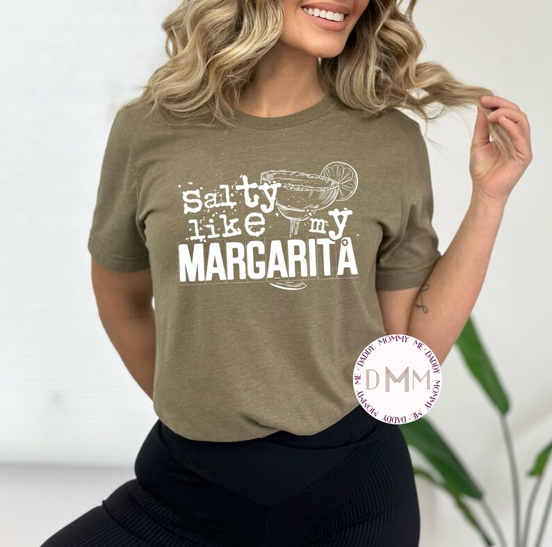 May include: A green t-shirt with the text "Salty like my Margarita" in white. The text is accompanied by a white illustration of a margarita glass with a lime wedge.