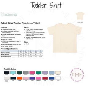 May include: A cream-colored Rabbit Skins toddler fine jersey t-shirt. The shirt features a topstitched ribbed collar, double-needle sleeves, and a bottom hem. Available in various colors, the shirt is machine washable and tumble dry low. Sizes range from 2T to 7.