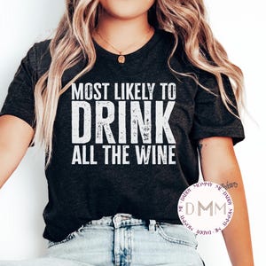 May include: A black t-shirt with white text that reads "Most Likely to Drink All the Wine".