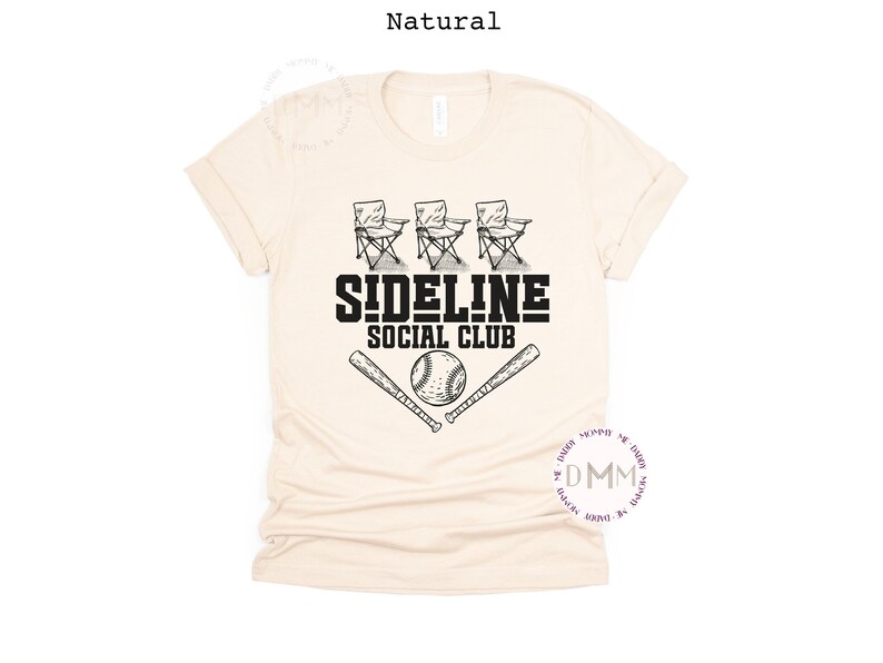 Op de afbeelding: Cr&egrave;mekleurig T-shirt met een zwart grafisch ontwerp. Het ontwerp toont drie klapstoelen, de tekst "SIDELINE SOCIAL CLUB", een honkbal en twee gekruiste honkbalknuppels. Het shirt is gemaakt van zacht materiaal.