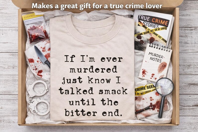 K&ouml;nnte beinhalten: Geschenkbox mit einem beigefarbenen T-Shirt mit dem Text "If I'm ever murdered just know I talked smack until the bitter end." Die Box enth&auml;lt auch Handschellen, ein Messer und einen Notizblock mit "Murder Notes."