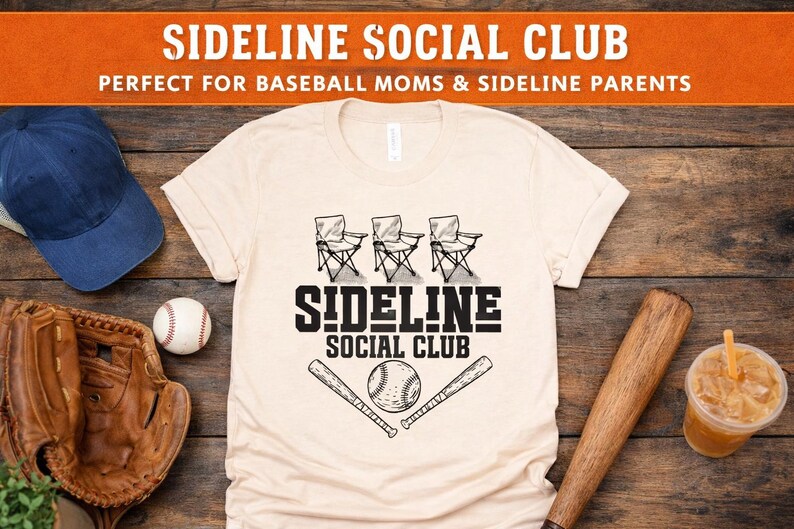 Op de afbeelding: Een cr&egrave;mekleurig t-shirt met een zwarte grafische print van drie klapstoelen, twee honkbalknuppels en een honkbal. De tekst SIDELINE SOCIAL CLUB staat in zwarte blokletters boven de afbeelding van de honkbal en knuppels.