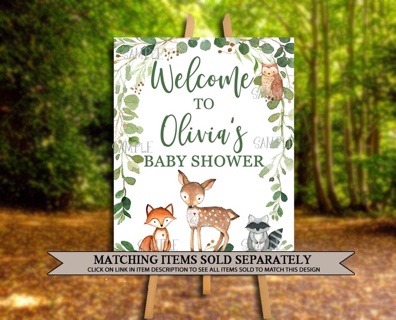 May include: Welcome to Olivia's Baby Shower sign with a green leafy border and woodland animal illustrations. The sign features a fox, a deer, a raccoon, and an owl.