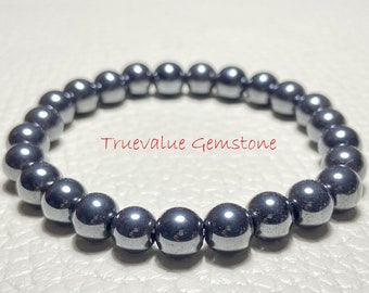 May include: A black hematite beaded bracelet with a shiny finish. The bracelet is made of round beads and is approximately 7 inches in length.