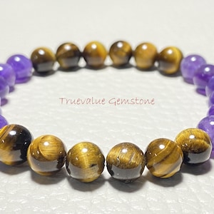 Könnte beinhalten: Ein Armband aus Amethyst- und Tigerauge-Perlen. Das Armband besteht aus abwechselnden Farben von Lila und Gold.