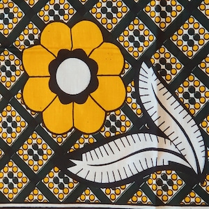 May include: A yellow flower with a black center and white leaves on a black and white patterned background.