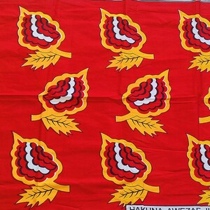 May include: Red fabric with a repeating pattern of stylized yellow leaves with red and white centers. The text "Hakuna Matata" is visible at the bottom of the image.