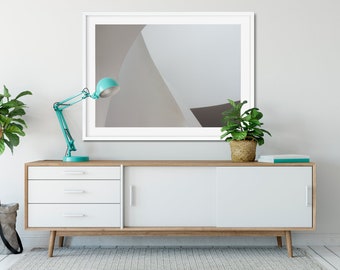 Peut inclure: Un buffet blanc de style mi-siècle moderne avec trois tiroirs et une porte coulissante. Une lampe de bureau bleu sarcelle avec un abat-jour blanc est posée sur le dessus du buffet. Une plante en pot est placée sur le côté droit du buffet. Une estampe abstraite encadrée est accrochée au mur au-dessus du buffet.