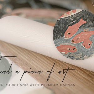 May include: Close-up of a canvas print with a textured surface. The print features a vintage illustration of red fish swimming in a blue pond. The text "Feel a piece of art" is printed on the wooden frame.