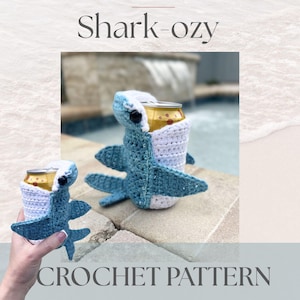 May include: A crochet pattern for a Shark-ozy, a shark-shaped can cozy. The cozy is blue and white, with a can inside. The text "COLDWATER SHORES" and "Shark-ozy" are at the top. The text "CROCHET PATTERN" is at the bottom.