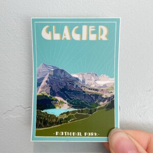 May include: A vintage-style poster with a blue background and white text that reads "Glacier National Park". The poster features a colorful illustration of a mountain range with a lake in the foreground.