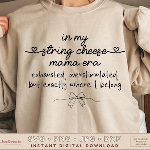 Könnte beinhalten: Ein beiges Sweatshirt mit schwarzem Text, der lautet: "in my string cheese mama era exhausted, overstimulated, but exactly where I belong." Das Design enthält Herz- und Schleifengrafiken. Der untere Teil des Bildes enthält den Text "SVG • PNG • JPG • DXF" und "INSTANT DIGITAL DOWNLOAD."