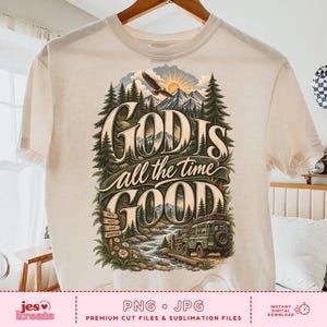 May include: A cream-colored short-sleeve t-shirt featuring a graphic print of a mountain landscape with pine trees, a river, an eagle, and a green off-road vehicle. The text reads "GOD IS all the time GOOD" with a small sign listing faith, hope, love, gratitude.