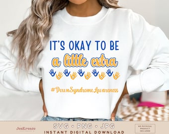 Pode incluir: Camisola branca com texto azul e amarelo que diz "Está bem ser um pouco extra" e uma fila de impressões de mãos amarelas com corações azuis. O texto "#Down Syndrome Awareness" está abaixo das impressões de mãos.