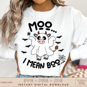 May include: White sweatshirt with a black and white illustration of a cow dressed as a ghost. The text "Moo... I mean Boo..." is printed on the shirt.