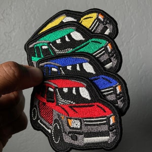 May include: Four embroidered patches of a black SUV in different colors: red, blue, green, and yellow. The patches are stacked on top of each other.