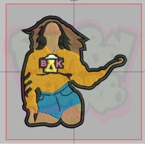 Peut inclure: Patch brodé représentant une femme de dessin animé portant un pull jaune avec le texte "BAK" sur le devant et un short en jean bleu. La femme a les cheveux bruns et est posée avec le bras levé.