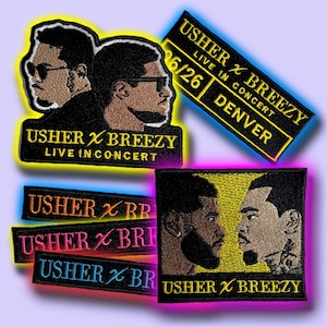 May include: Embroidered patches featuring Usher and Breezy. The patches include text that reads "USHER X BREEZY LIVE IN CONCERT" and "DENVER 6/26". The patches are in various colors, including black, orange, pink, and blue.