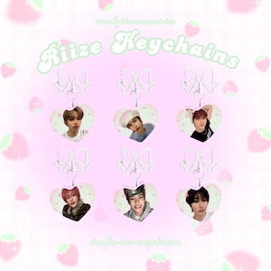 May include: Heart-shaped keychains featuring images of people, suspended from silver-colored bows. The keychains are arranged on a pink background with strawberry illustrations. The text "Riize Keychains" is displayed at the top, with "info in caption" at the bottom.