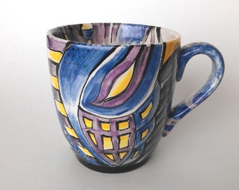 Hand painted ceramic mug in blues, purples and oranges