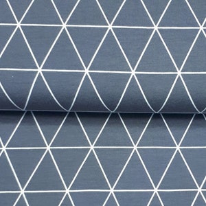 Pode incluir: Um close-up de um tecido com um padrão geométrico de triângulos brancos sobre um fundo azul escuro.