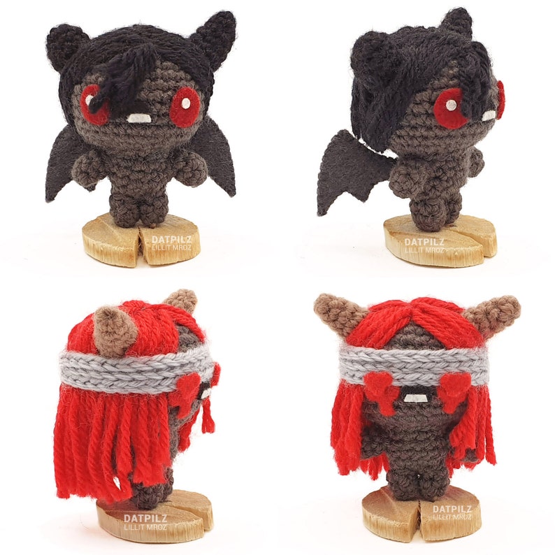 May include: Four crocheted amigurumi figures. Two are black with red eyes and wings, and two are red with grey eyes and a grey headband. Each figure is standing on a wooden base with the text 'DATPILZ LILLIT MROZ' on it.