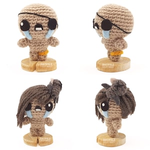 May include: Four crocheted figures with tearful faces. Two figures are standing on wooden bases with the text 'DATPILZ LILIT MR02'. Two figures are standing on wooden bases with the text 'DATPILZ LILIT MR02'.