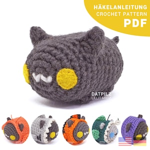 Könnte beinhalten: Häkelanleitung PDF für eine süße graue Amigurumi-Figur mit gelben Augen. Die Anleitung enthält Anweisungen zum Herstellen der Figur in verschiedenen Farben, darunter Orange, Grau, Grün und Lila.