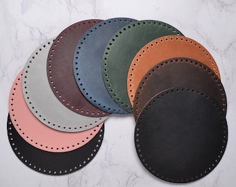 Op de afbeelding: Assortiment van acht ronde lederen stukken met gaten rond de randen. De stukken zijn in verschillende kleuren, waaronder zwart, bruin, grijs, roze, groen, blauw en bordeaux.