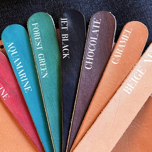 May include: Leather swatches in various colors, including red wine, aquamarine, forest green, jet black, chocolate, caramel, beige nude.