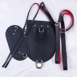 May include: A black leather bag with red stitching and silver hardware. The bag has a top handle and a long adjustable strap. The bag is disassembled and laid out flat on a white surface.