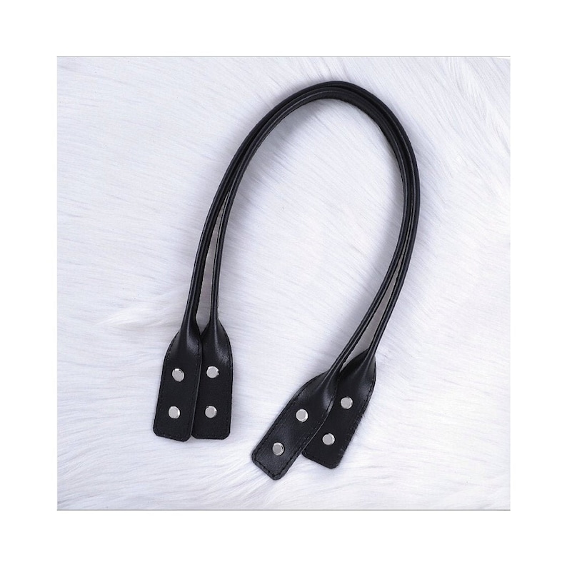 Puede incluir: Un par de asas de bolso de cuero negro con remaches de metal plateado.