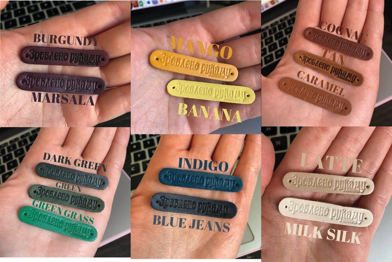 Puede incluir: Una colecci&oacute;n de etiquetas de cuero en varios colores, incluyendo burdeos, marsala, mango, pl&aacute;tano, co&ntilde;ac, marr&oacute;n, caramelo, verde oscuro, verde, verde hierba, &iacute;ndigo, azul vaquero, latte y leche de seda. Cada etiqueta tiene el texto "Зроблено руками" (que significa "Hecho a mano") grabado en relieve.