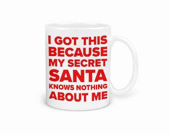 May include: White ceramic mug with a curved handle. The mug features the red text: "I GOT THIS BECAUSE MY SECRET SANTA KNOWS NOTHING ABOUT ME."