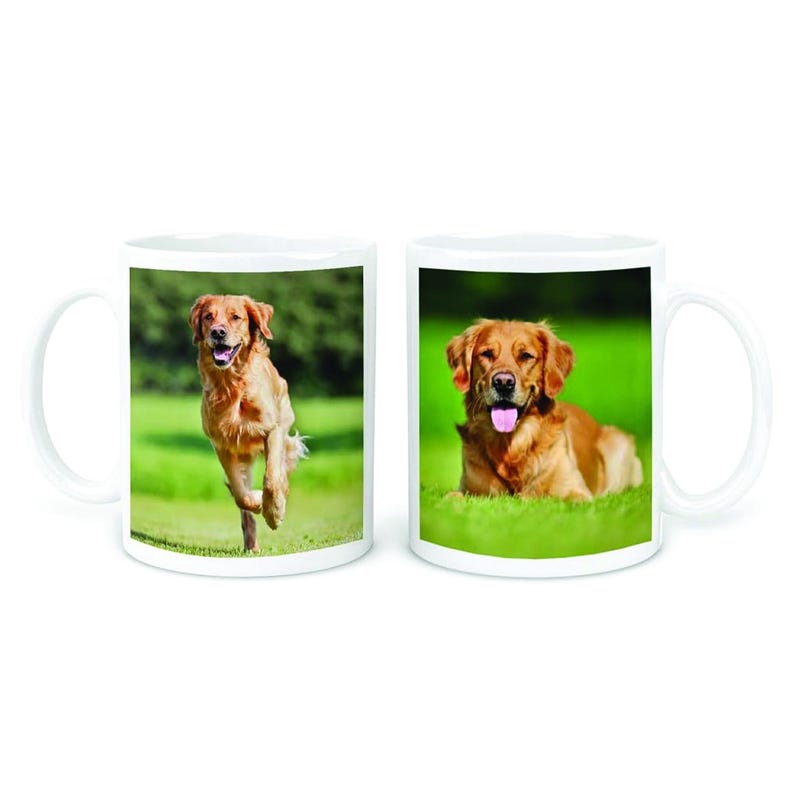 May include: Two white ceramic mugs featuring images of a golden retriever dog. One mug depicts the dog running in a grassy field, while the other mug shows the dog lying down in the grass.
