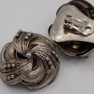 Peut inclure: Une paire de boucles d'oreilles clips en argent avec un motif en spirale et une finition textur&eacute;e.