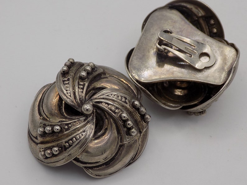Peut inclure: Une paire de boucles d'oreilles clips en argent avec un motif en spirale et une finition textur&eacute;e.