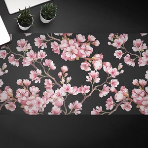 May include: A black background with a repeating pattern of pink cherry blossoms. The blossoms are in full bloom and have a watercolor effect.
