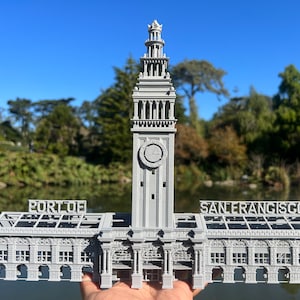 May include: A gray 3D printed model of the Ferry Building in San Francisco. The model includes the clock tower and the words "PORT OF" and "SAN FRANCISCO" on the roof.