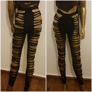 Könnte beinhalten: Schwarze Leggings mit mehreren horizontalen Schlitzen, die in den Stoff geschnitten sind. Die Leggings befinden sich auf einem Mannequin.
