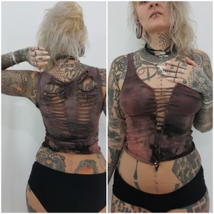 Op de afbeelding: Een bruin en zwart tie-dye tanktop met een uitgesneden ontwerp op de rug. Het topje is gecropped en heeft een vetersluiting aan de voorkant.