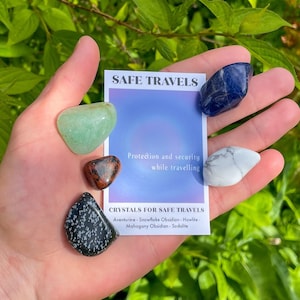 May include: A set of crystals for safe travels, including aventurine, snowflake obsidian, howlite, mahogany obsidian, and sodalite. The crystals are arranged on a card that reads "Safe Travels" and "Protection and security while travelling".