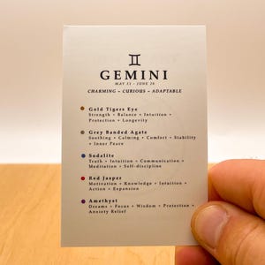 Peut inclure: Une carte blanche avec le signe du zodiaque G&eacute;meaux et les dates du 21 mai au 26 juin. La carte liste les cristaux suivants et leurs propri&eacute;t&eacute;s : &OElig;il de Tigre Dor&eacute;, Agate Band&eacute;e Grise, Sodalite, Jaspe Rouge et Am&eacute;thyste.