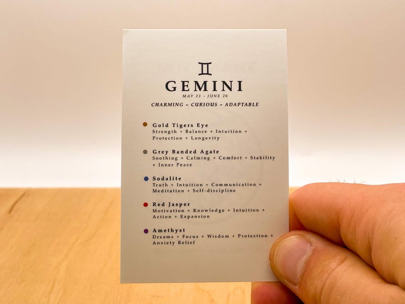 Peut inclure: Une carte blanche avec le signe du zodiaque G&eacute;meaux et les dates du 21 mai au 26 juin. La carte liste les cristaux suivants et leurs propri&eacute;t&eacute;s : &OElig;il de Tigre Dor&eacute;, Agate Band&eacute;e Grise, Sodalite, Jaspe Rouge et Am&eacute;thyste.