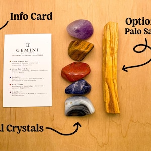 Peut inclure: Un ensemble de sept cristaux naturels, comprenant de l'am&eacute;thyste, de l'&oelig;il de tigre, du jaspe rouge, de la sodalite, de l'agate ruban&eacute;e grise et d'une agate claire, dispos&eacute;s verticalement sur une surface en bois. Une carte d'information avec le signe du zodiaque G&eacute;meaux et une description des cristaux est incluse. Un b&acirc;ton de Palo Santo en option est &eacute;galement inclus.