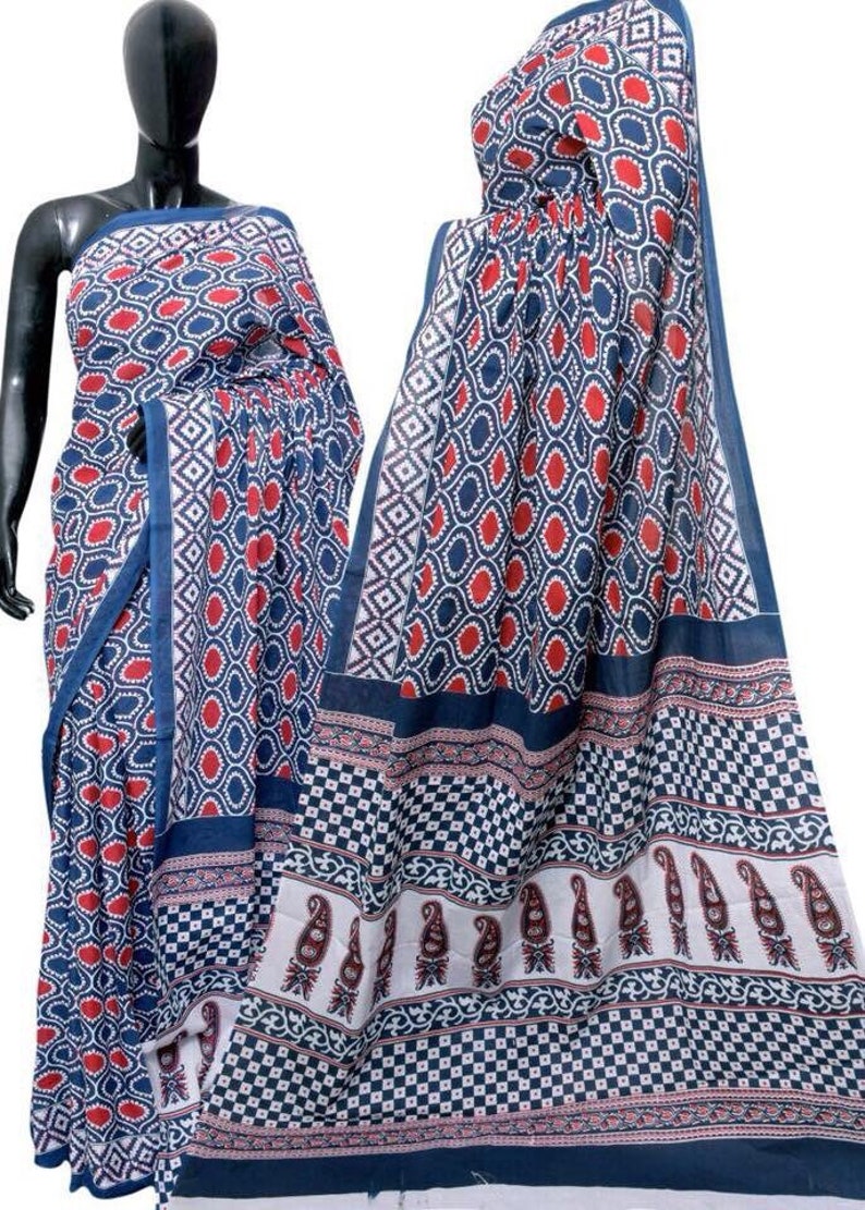 May include: A blue and white cotton saree with a red and white geometric pattern. The saree has a paisley border.