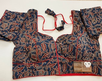 May include: A blue and red floral printed cotton blouse with a red trim and a tie-up neckline. The blouse has short sleeves and is labeled "XL".