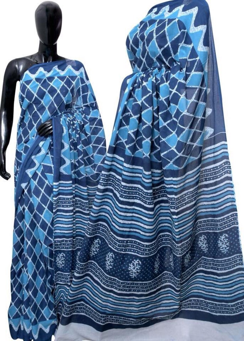 May include: A blue and white cotton saree with a geometric pattern. The saree has a border with a floral design.