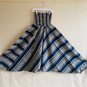 May include: Striped blue and white wide-leg pants with an elastic waistband. The pants are gathered at the bottom and have a loose, flowing fit.