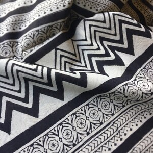 May include: Black and white fabric with a geometric pattern. The fabric has a zig-zag pattern, a floral pattern, and a striped pattern.